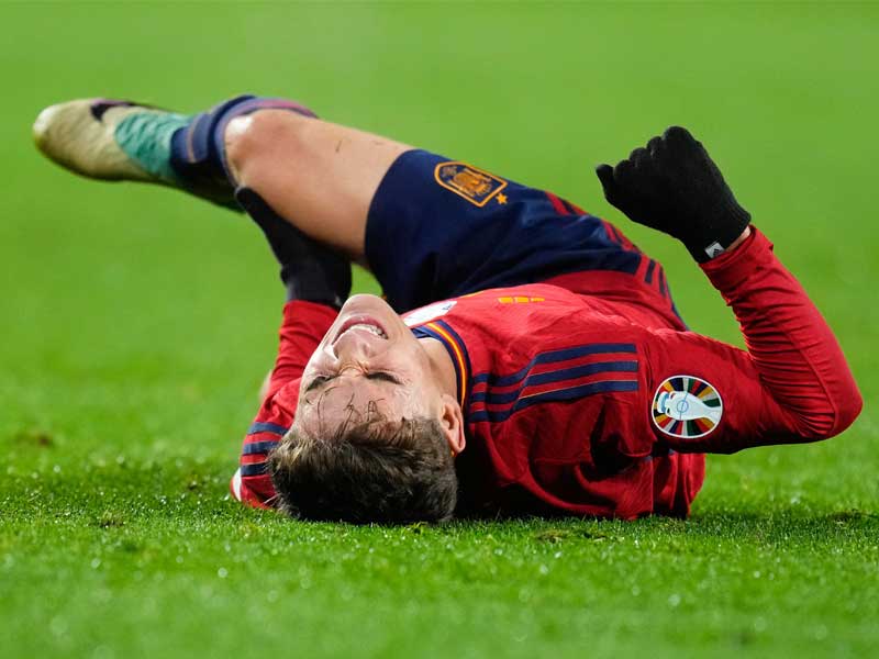 Gavi ôm đầu gối đau đớn, một hình ảnh biểu tượng cho sự khắc nghiệt của bóng đá hiện đại với các cầu thủ trẻ.
